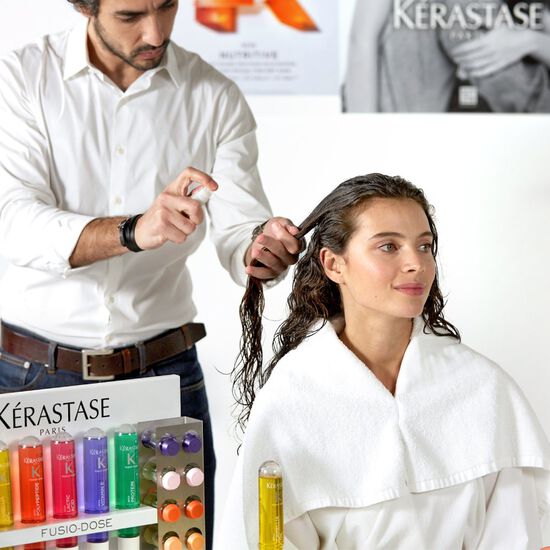 Eine Frau beim Friseur, die eine Fusio-Dose-Behandlung bekommt