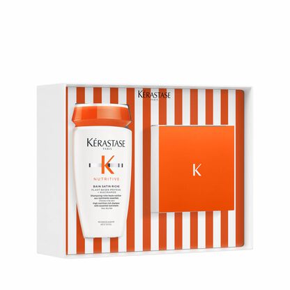 Ein Kerastase Haarpflege-Set in einer eleganten Verpackung mit einer Flasche Balsam Satin Riche in Orange und Weiß.