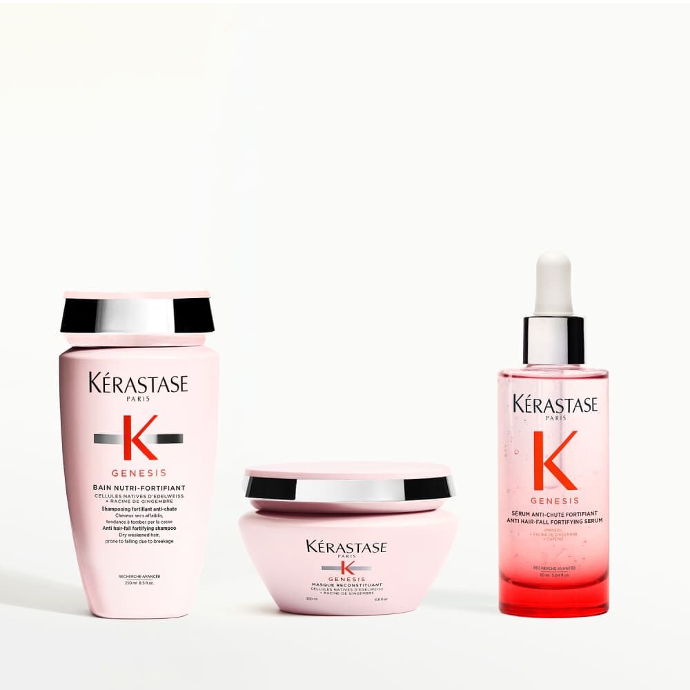Kerastase Genesis Produktprasentation mit Shampoo, Conditioner, Serum, Kamm und Handen, die Beeren halten.