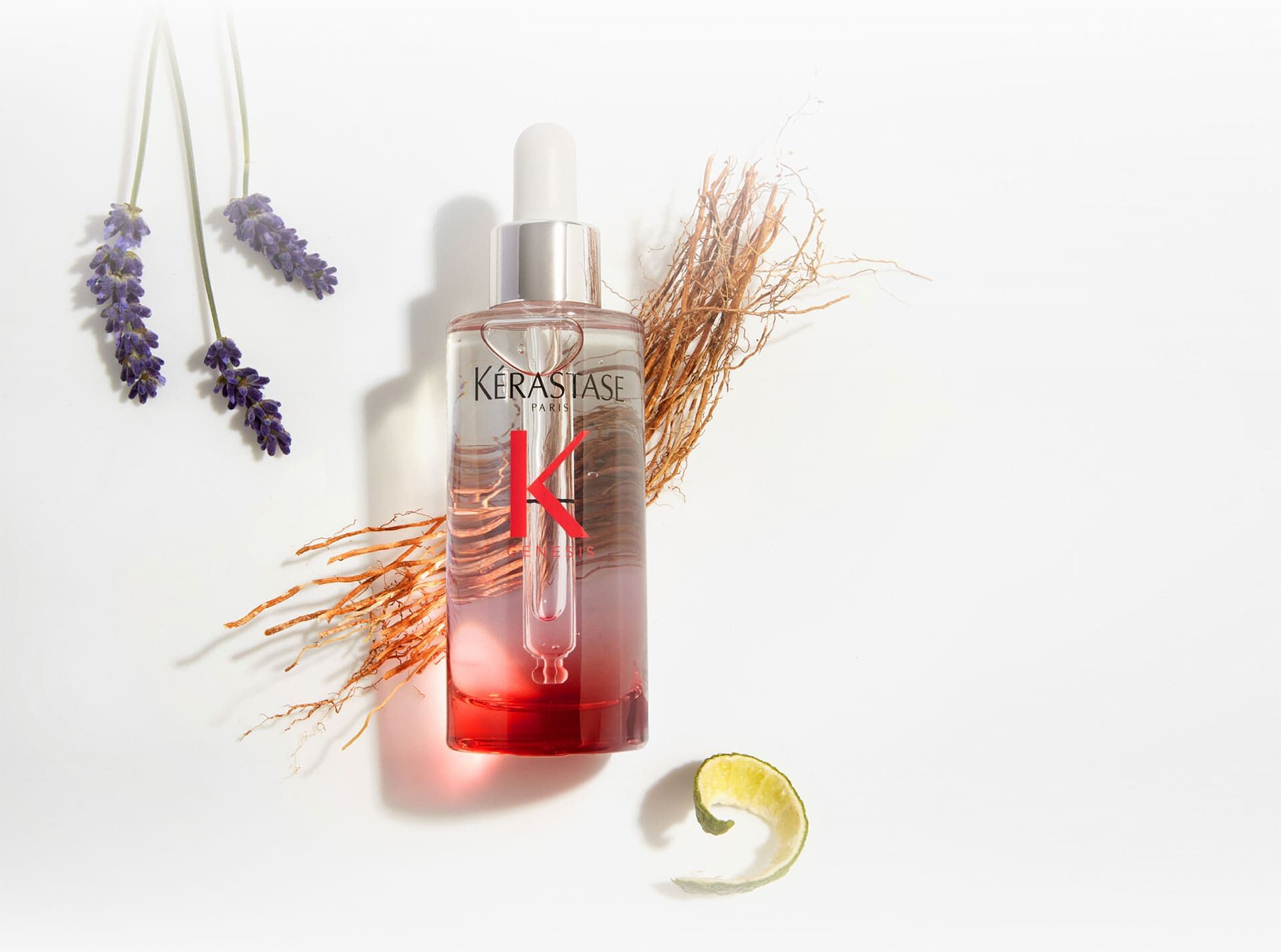 Flasche des Kerastase Genesis Serum Anti-Chute Fortifiant, umgeben von botanischen Elementen wie Lavendel und Ingwer.