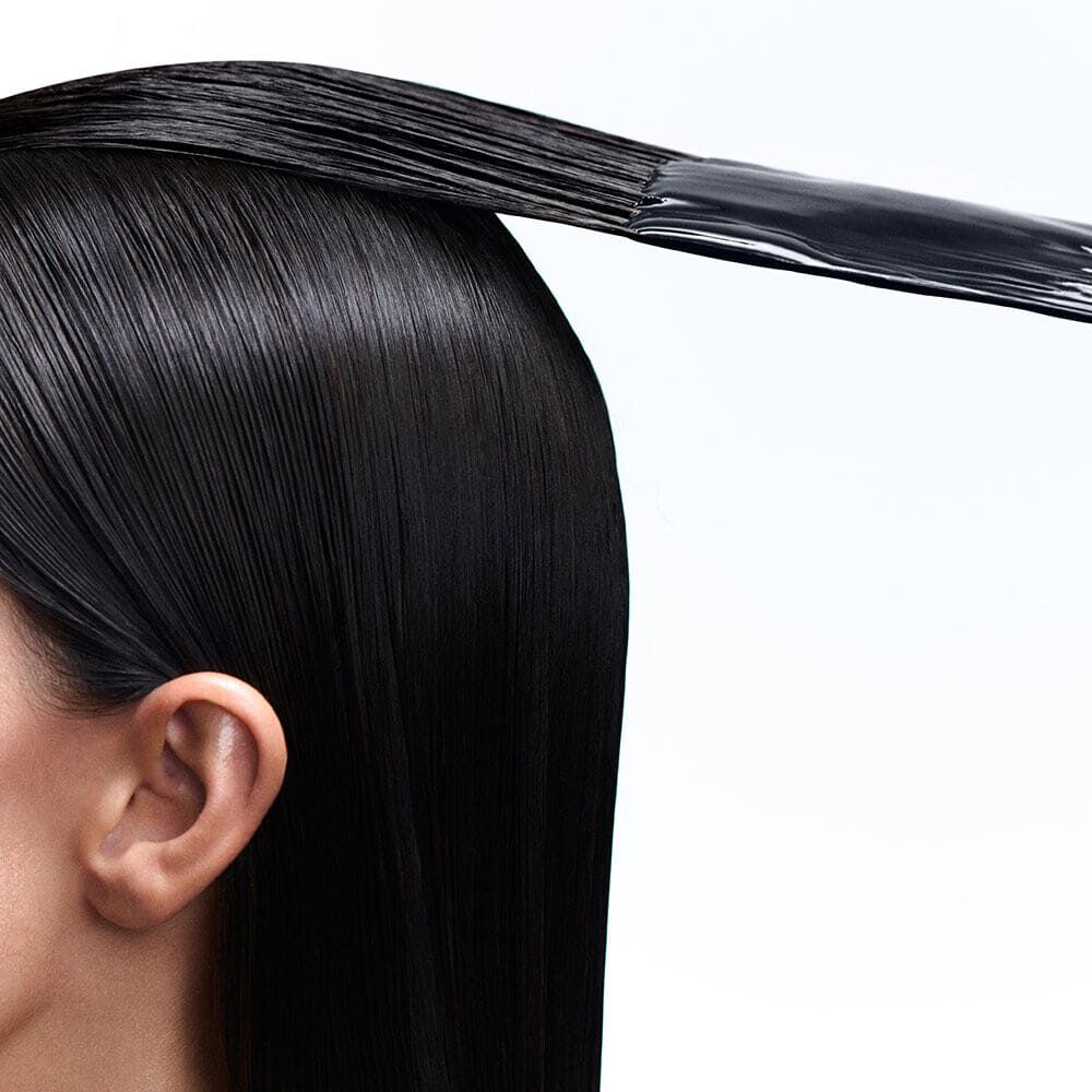 Dunkles glattes Haar mit Produktauftrag.