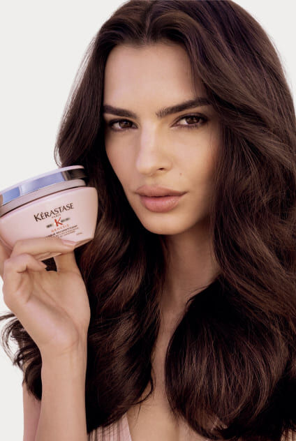 Rosa Tiegel der Kerastase Genesis Masque Reconstituant Maske, auf transparenten Blocken platziert.