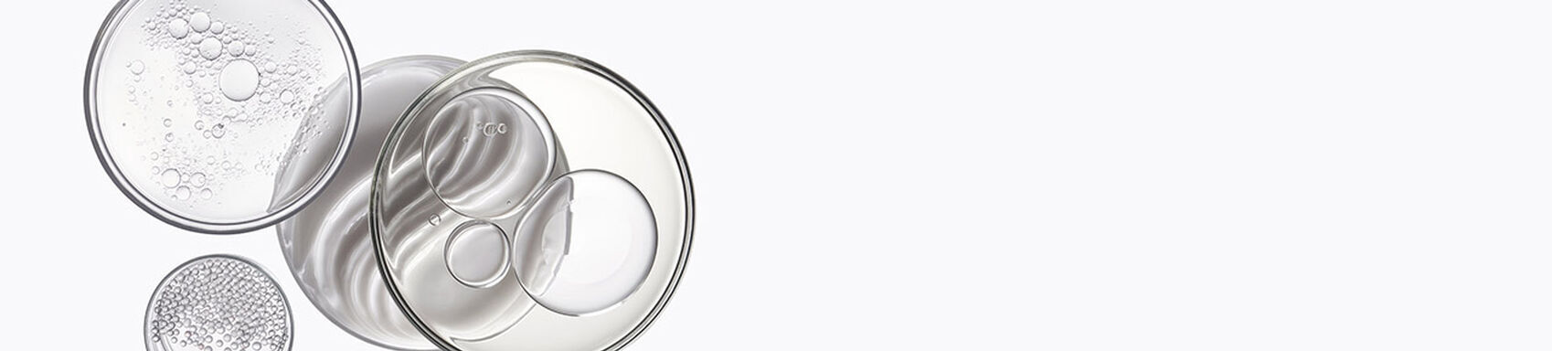 Glasbehalter mit transparenten Flussigkeiten, Blasen und Kugeln.