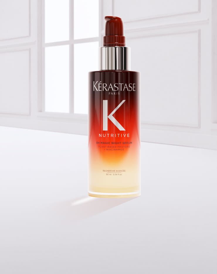 Eine Flasche Haarpflegeprodukt von Kerastase mit einem Gradient-Design, umgeben von einem Tropfen des Produkts auf einem hellen Hintergrund.