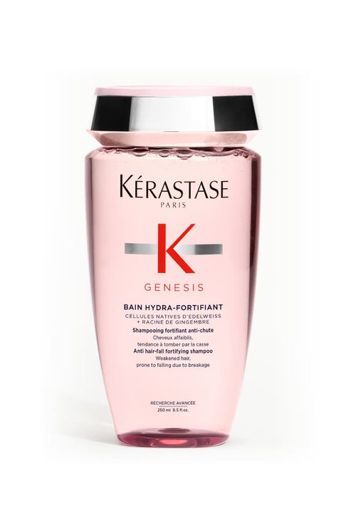 Transparentrosa Flasche des Kerastase Genesis Bain Hydra-Fortifiant Shampoos fur geschwachtes Haar, geneigt.