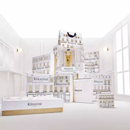 Dekorative Anordnung von weißen und goldenen Kerastase Geschenkboxen und Verpackungen, wahrscheinlich aus der Elixir Ultime Serie.