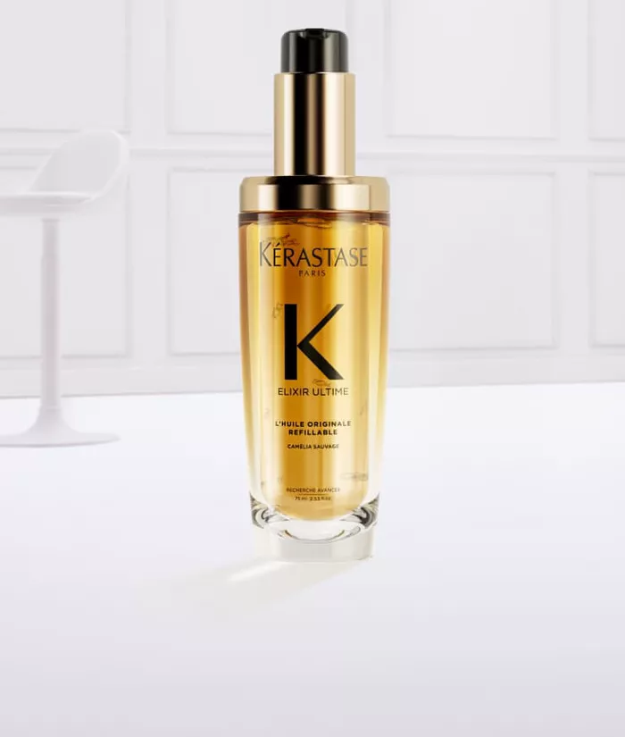 Ein flussiges Haarserum in einer eleganten Flasche mit Goldakzenten, umgeben von spritzendem, goldenem Serum.