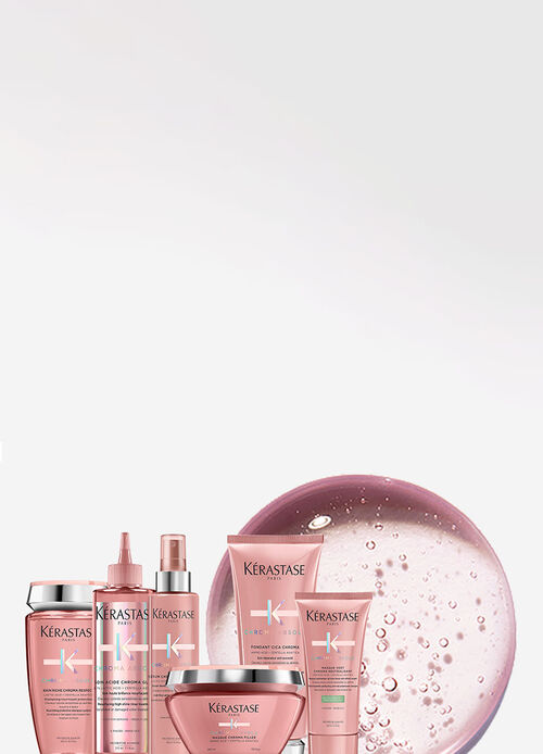 A collection of Kerastase hair care products featuring various bottles and jars, arranged artistically against a vibrant pink background.