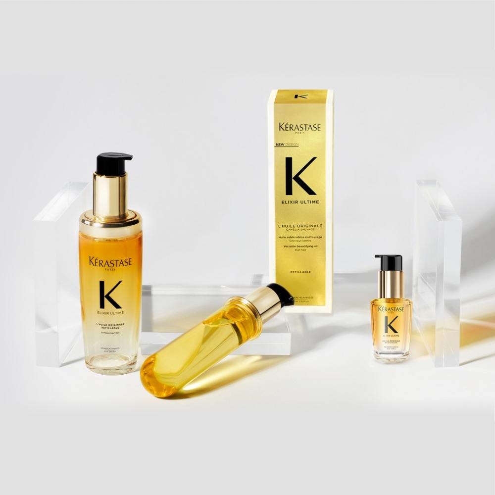 Das neue Haaröl Elixir Ultime, seine Nachfüllpackung und sein Reiseformat werden auf transparenten Würfeln auf rein grauem Hintergrund präsentiert.