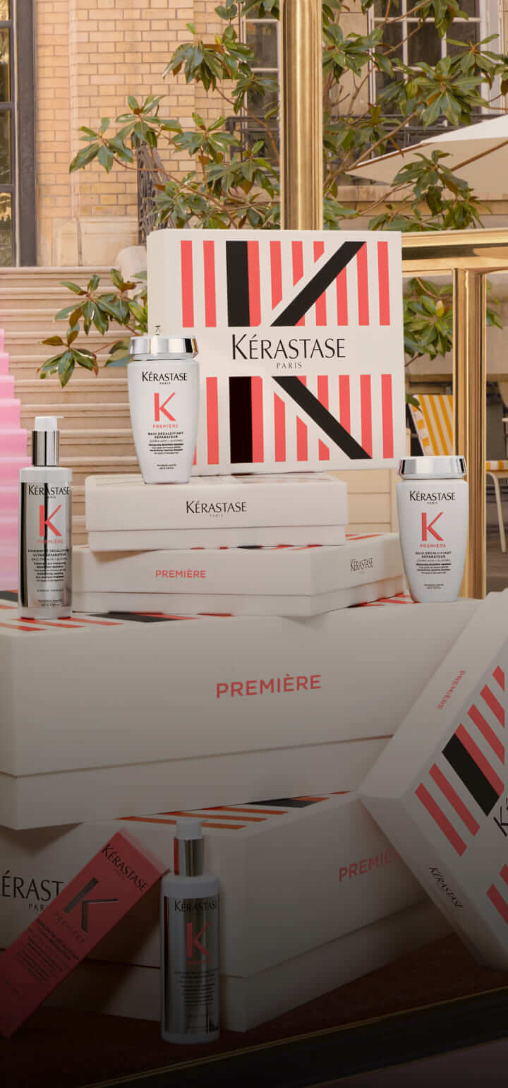 Eine Präsentation von Kérastase-Haarpflegeprodukten in stilvollen, gestapelten Verpackungen in einem eleganten Ambiente.