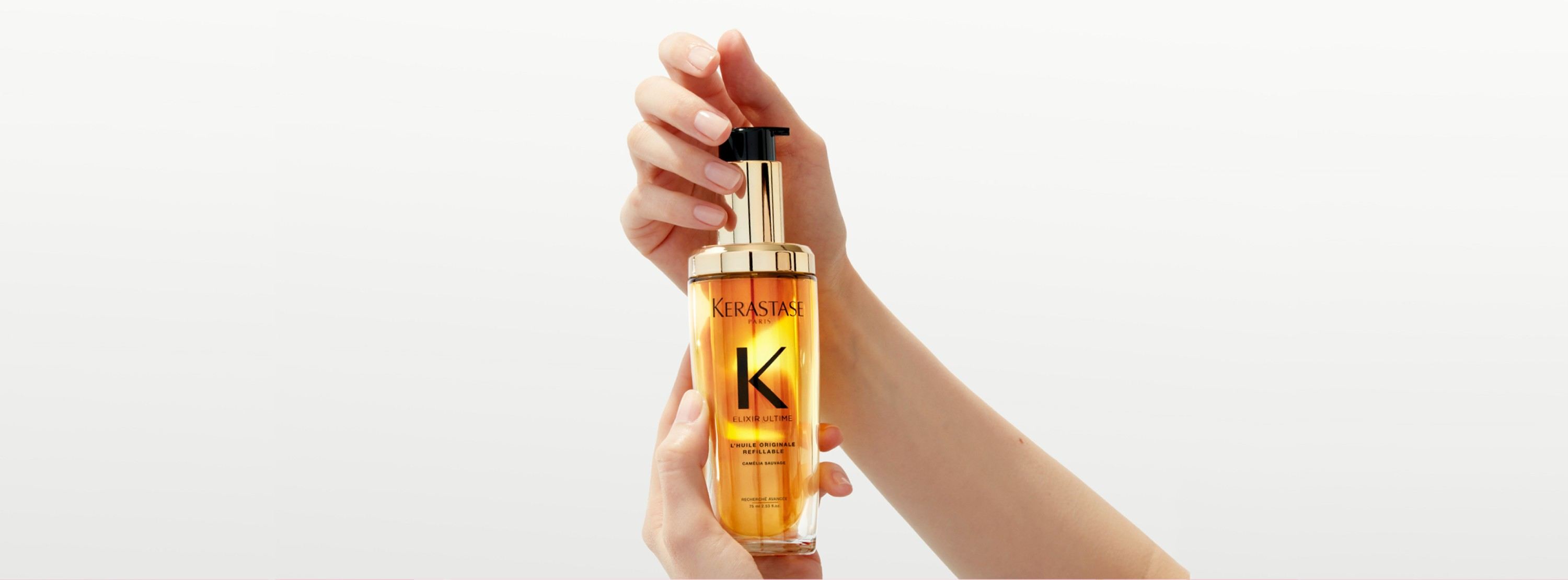 Das neue nachfüllbare Elixir Ultime wird in einer Drehbewegung mit zwei Händen gehalten.
